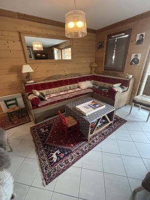 A cozy living room with a sofa, a small table, a lamp, and a rug. - 350m from ski slopes, 1st floor, terrace, ski locker, 68m², Les Gets (Les Gets)