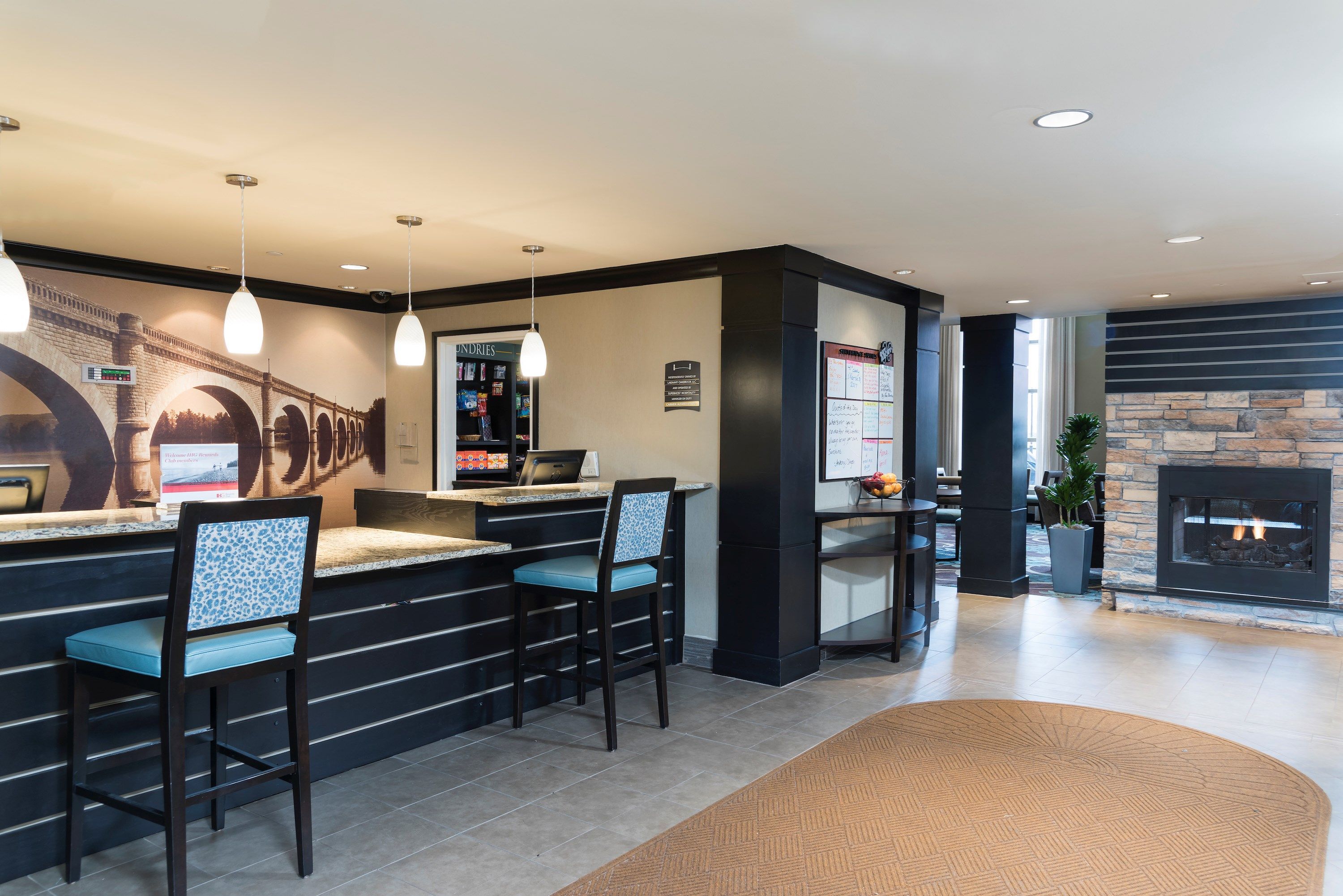 A reception area with a bar, seating, a fireplace, and a mural.