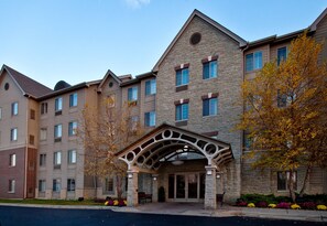 A multi-story hotel with a stone facade, a covered entrance, and a parking lot.