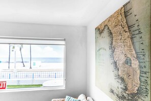 Ein Zimmer mit einer großen Wandkarte, einem Fenster mit Blick auf den Strand und einem roten Fluchtzeichen.