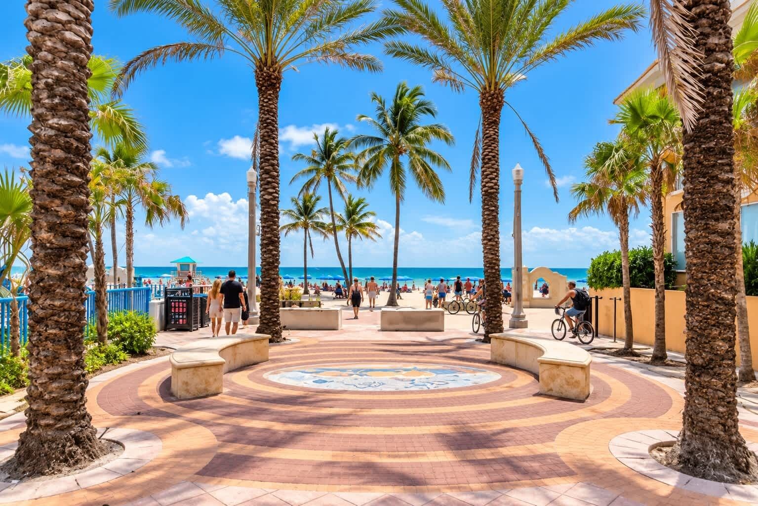 A paved walkway with palm trees, benches, and a view of the beach and ocean.