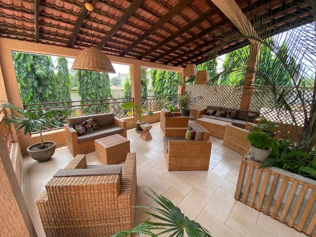 An outdoor seating area with wicker furniture and potted plants.