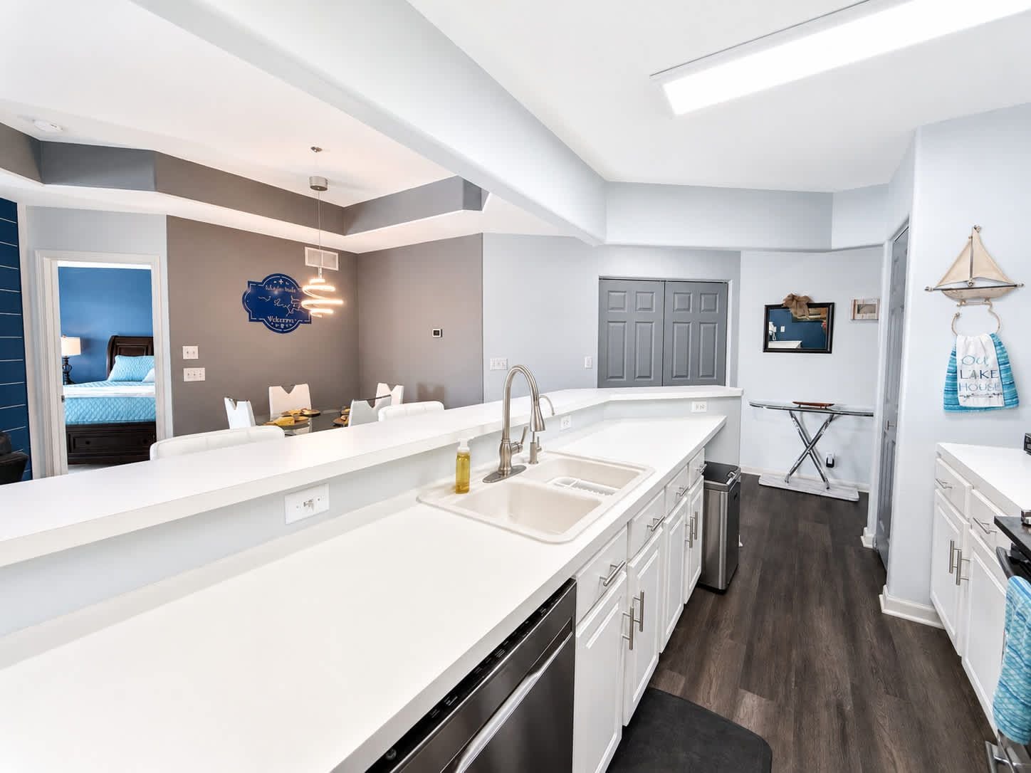 A modern kitchen with a large island, a built-in dishwasher, and a compact layout.