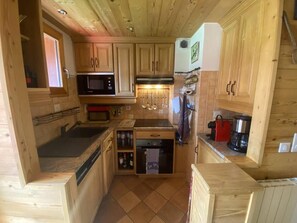 A compact kitchen with wooden cabinets, a microwave, a coffee maker, and a built-in oven. - Ski-in/ski-out & foot of the slopes, 3rd floor, balcony, ski locker, 52m², Valmorel (Valmorel)
