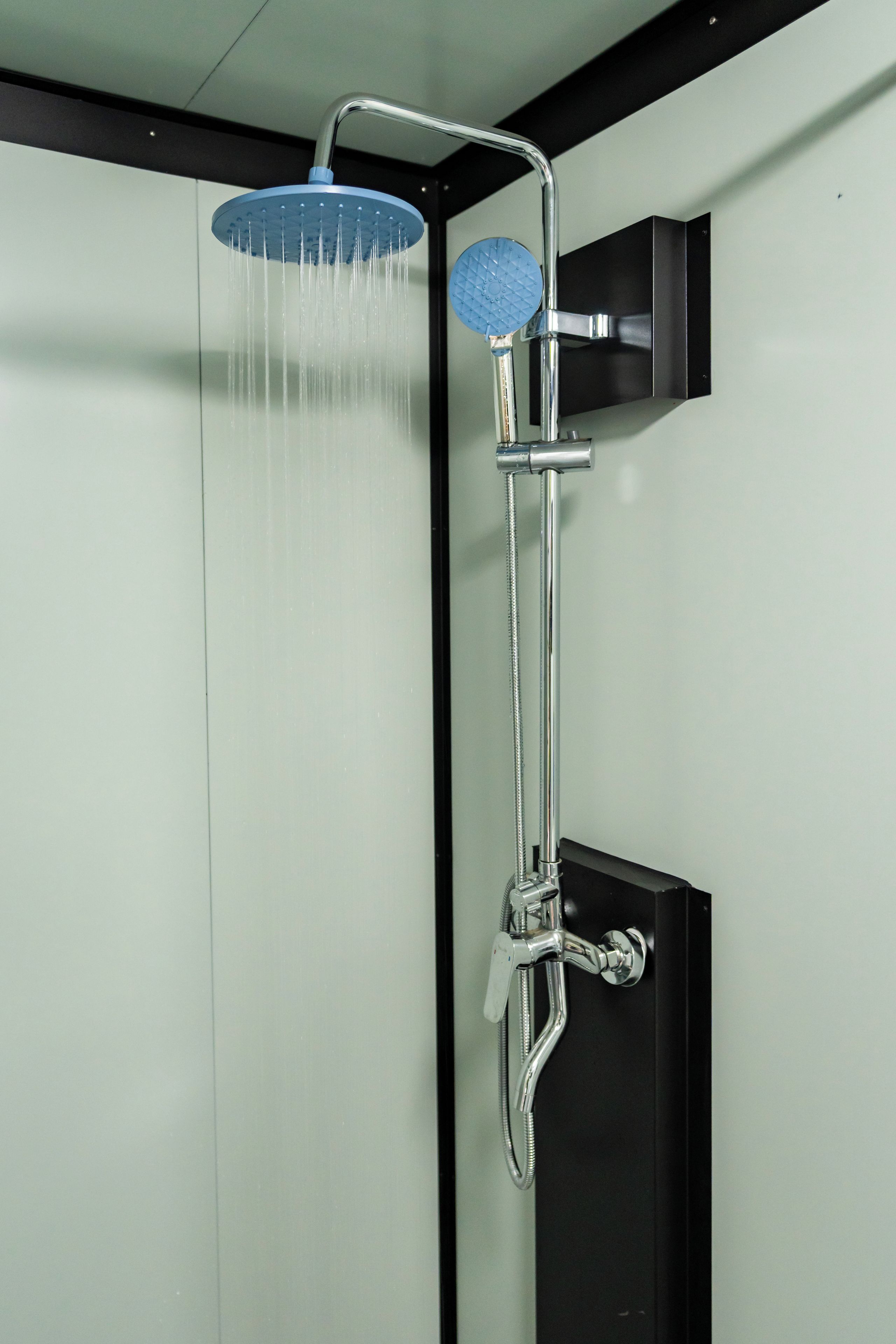 Une douche équipée d’un pommeau de douche à main et d’un pommeau de douche fixe au plafond.
