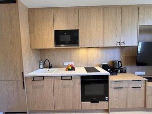 A modern kitchen with wooden cabinets, a built-in microwave, a dishwasher, and a coffee maker. - 50m from ski slopes, 7th floor, tv, ski locker, 23m², Vars (Vars)
