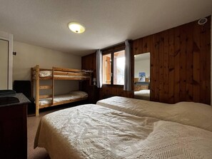 A room with bunk beds, a desk, and a window with curtains. - 10m from ski slopes, 1st floor, tv, ski locker, 45m², Val Cenis (Lanslevillard)