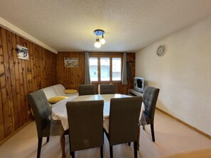 A dining area with a table, chairs, a sofa, and a television. - 10m from ski slopes, 1st floor, tv, ski locker, 45m², Val Cenis (Lanslevillard)