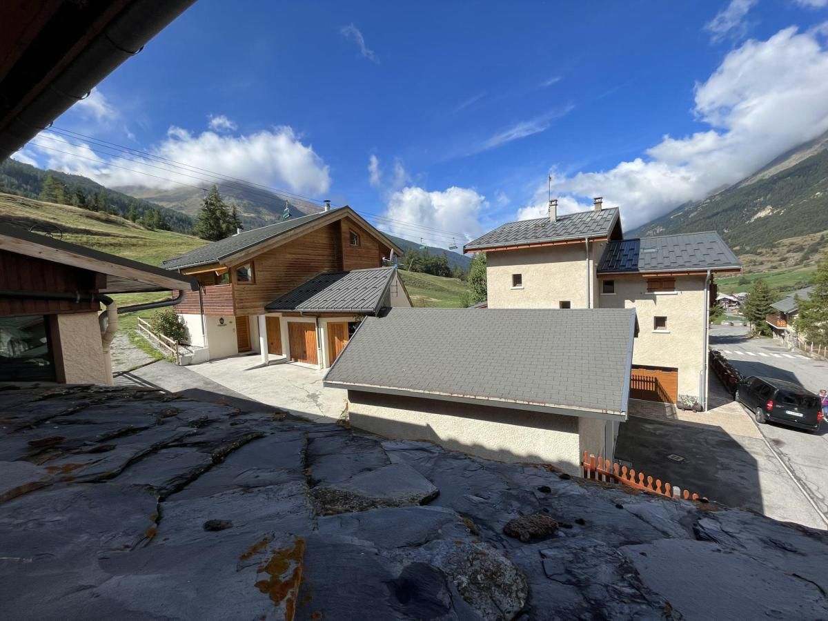 A traditional chalet with a stone foundation, wooden exterior, and a sloped roof.