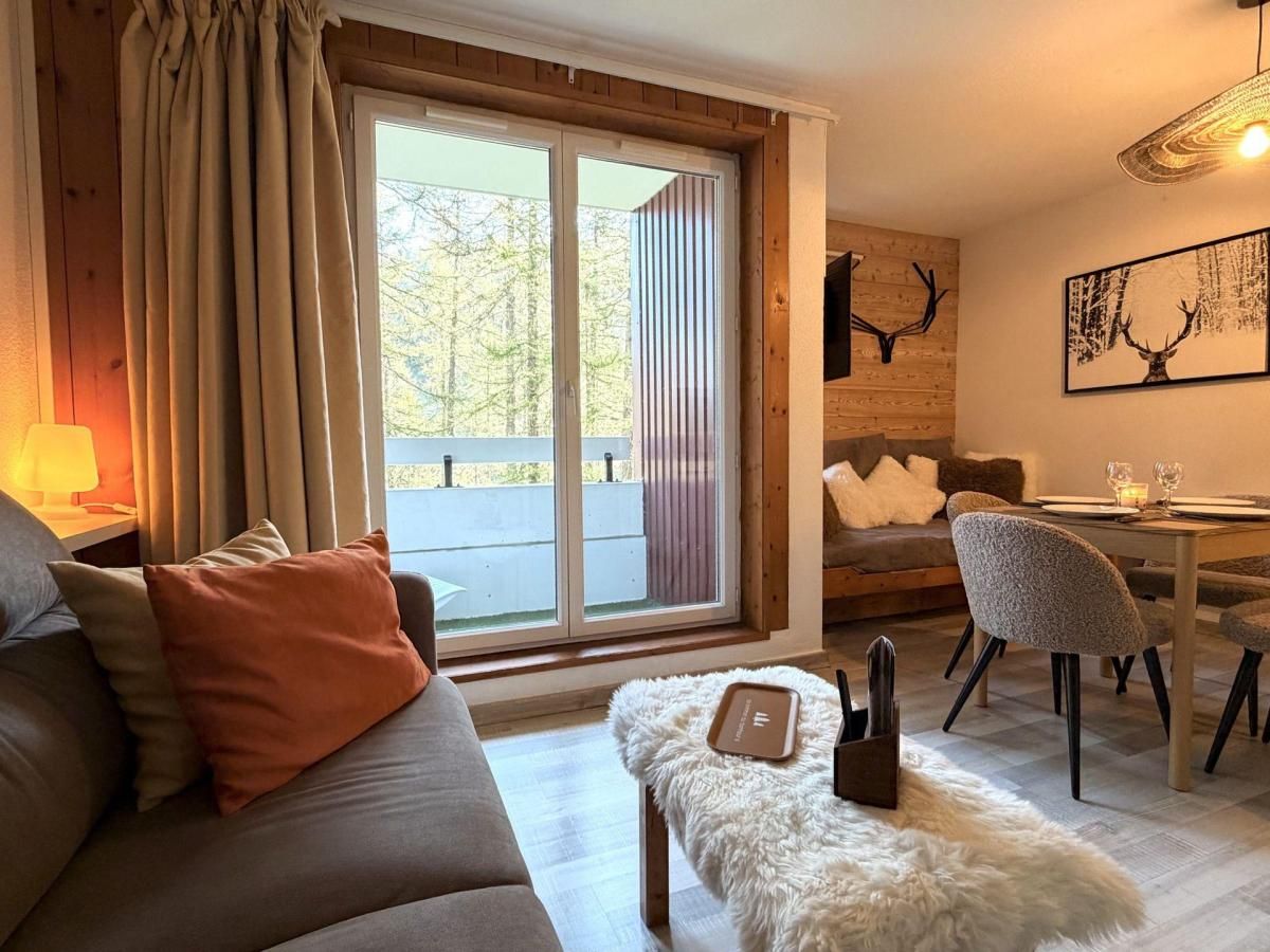 Ein gemütliches Wohnzimmer mit Sofa, Esstisch und Kamin.