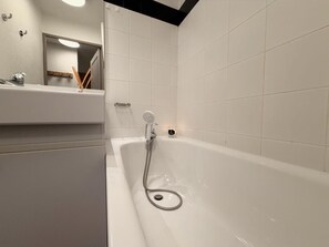 A bathroom with a bathtub, a mirror, and a sink. - 100m from ski slopes, 3rd floor, balcony, tv, ski locker, 27m², Vars (Vars)