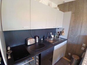 A compact kitchen with a black countertop, a toaster, a kettle, and a sink. - 250m from ski slopes, balcony, tv, ski locker, 28m², Alpe d'Huez (L'Alpe d'Huez)