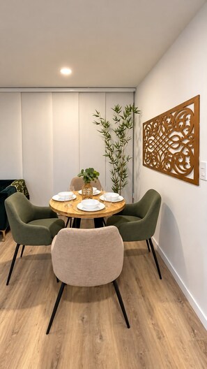 A dining area with a round table, four chairs, and a decorative wall piece. - BORA Ventura 104: Your Space Away from Home (Ibagué)