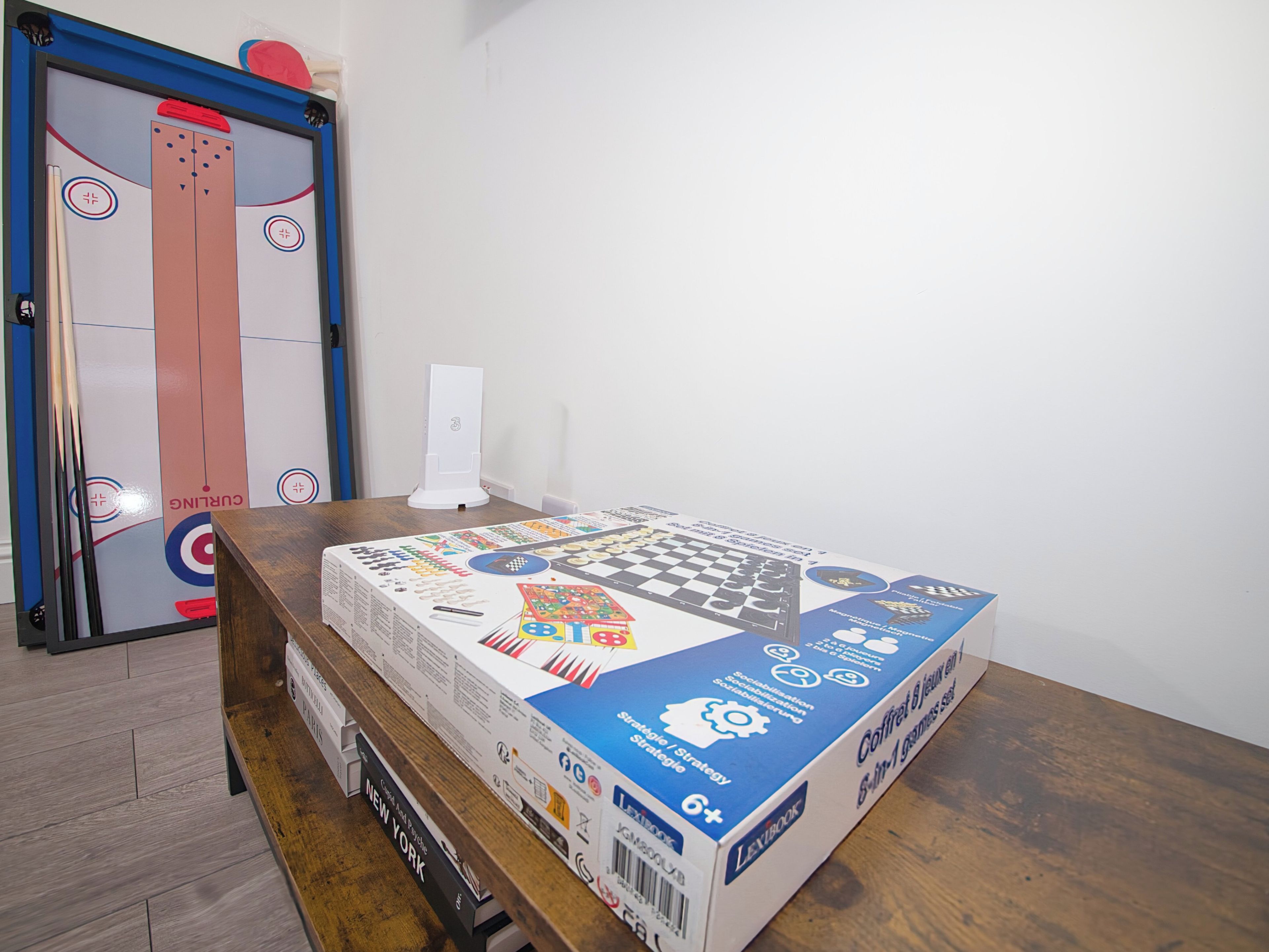 A table with a board game box and a curling puck on it.