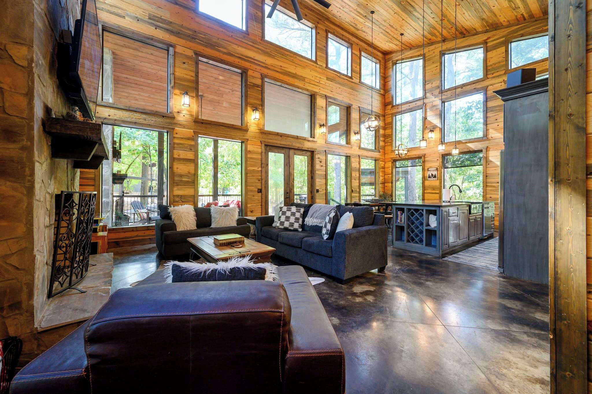 A spacious living area with a large couch, a coffee table, and a fireplace.