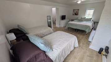 Une chambre avec deux lits, une commode, un miroir et un téléviseur.