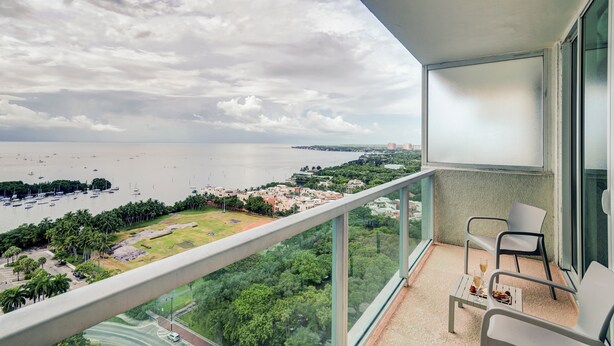 Varanda com vista para um porto de iates e o horizonte urbano.