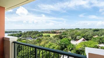 A balcony with a view of a coastal area, including a marina and residential buildings.