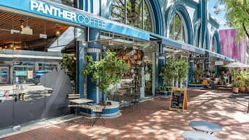 A coffee shop named 'Panther Coffee' with outdoor seating and a view of the street.