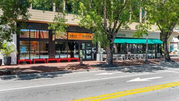 A street with a restaurant named 'Salt & Straw' and another named 'green' with outdoor seating.