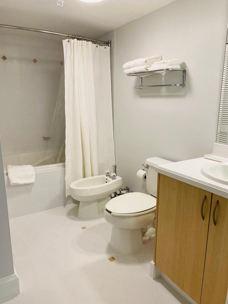 A bathroom with a bathtub, a bidet, a toilet, and a sink.