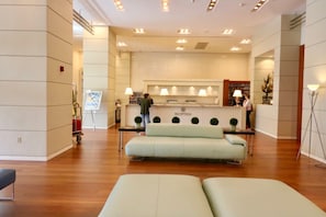 A hotel reception area with a reception desk, a sofa, and a floor lamp. - Coconut Grove: 10th Floor Private Unit -parking Included (Miami)