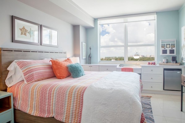 A bedroom with a large bed, a window with a city view, a bedside table, and a dresser. - Coconut Grove: 10th Floor Private Unit -parking Included (Miami)