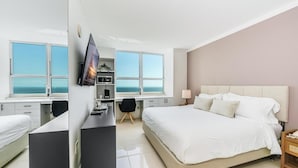 A hotel room with a bed, desk, and TV. - Coconut Grove: Bayview Unit. Parking Included (Miami)