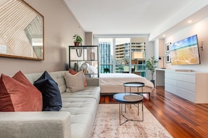 A modern hotel room with a sofa, a bed, a small table, and a TV. - Coconut Grove Studio: Sleeps 4 Includes Parking (Miami)