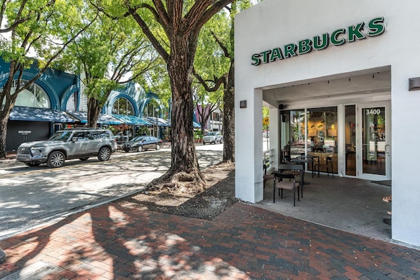 A Starbucks with a brick sidewalk and trees. - Coconut Grove Studio: Sleeps 4 Includes Parking (Miami)