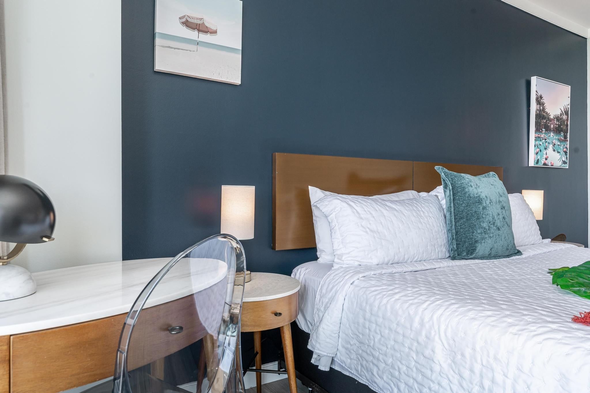Une chambre d’hôtel avec un lit, des tables de chevet, un bureau et une chaise.