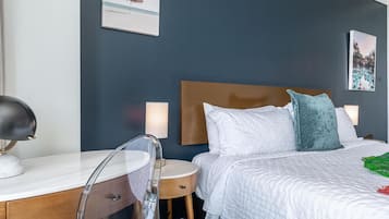 Une chambre d’hôtel avec un lit, des tables de chevet, un bureau et une chaise.