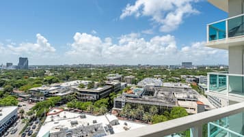 Un immeuble de grande hauteur offrant une vue sur le paysage urbain, avec divers bâtiments et des espaces verts.