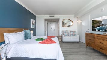 Quarto com cama, penteadeira, sofá, espelho e um quadro.