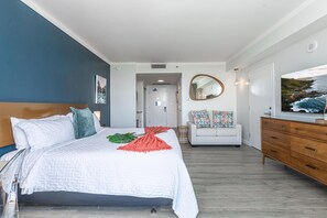 Un dormitorio con cama, cómoda, sofá, espejo y un cuadro.