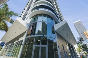 A modern high-rise building with a curved glass facade and a prominent entrance. - Modern Downtown Miami Studio Sleeps 4 Steps to Miami Worldcenter & Arena (Miami)