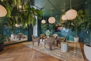 A modern lounge area with wooden flooring, wicker furniture, hanging plants, and large paper lanterns. - Modern Downtown Miami Studio Sleeps 4 Steps to Miami Worldcenter & Arena (Miami)
