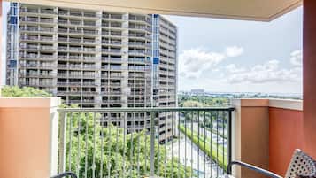 Ein Balkon mit Blick auf ein Hochhaus, einem Geländer und einem Tisch mit einer Zitronenschale.
