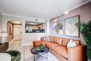 A modern living room with a leather sofa, a coffee table, and a dining area with a lamp. - Coconut Grove Beauty! 1/1 Bayview Condo w/ Free Parking (Miami)