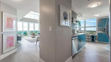 A modern kitchen with a large window, a dining area with a view, and artwork on the walls.