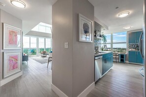A modern kitchen with a large window, a dining area with a view, and artwork on the walls. - Luxury 2-story Penthouse Located in Coconut Grove Hotel-includes Parking (Miami)