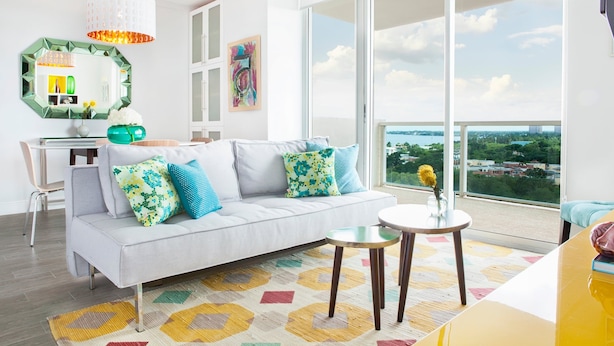 A modern living room with a sofa, a dining table, and a view of the city. - Private 2/2.5 bay View Apt. in Coconut Grove Hotel Includes Parking! (Miami)