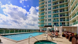 A rooftop pool area with a hot tub, lounge chairs, and a view of the ocean. - Coconut Grove:10th Fl Studio-parking Included (Miami)