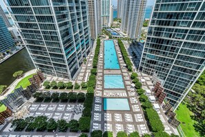 A high-rise building with multiple swimming pools and sun loungers. - Icon Brickell Miami- 2 Bedroom Condo With City and Water Views! (Miami)