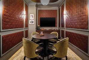 A room with a round table, four chairs, a flat-screen TV, and a wall with a patterned design. - Luxury Wynwood 2BR Pool, Gym, Walk to Restaurants & Art (Miami)