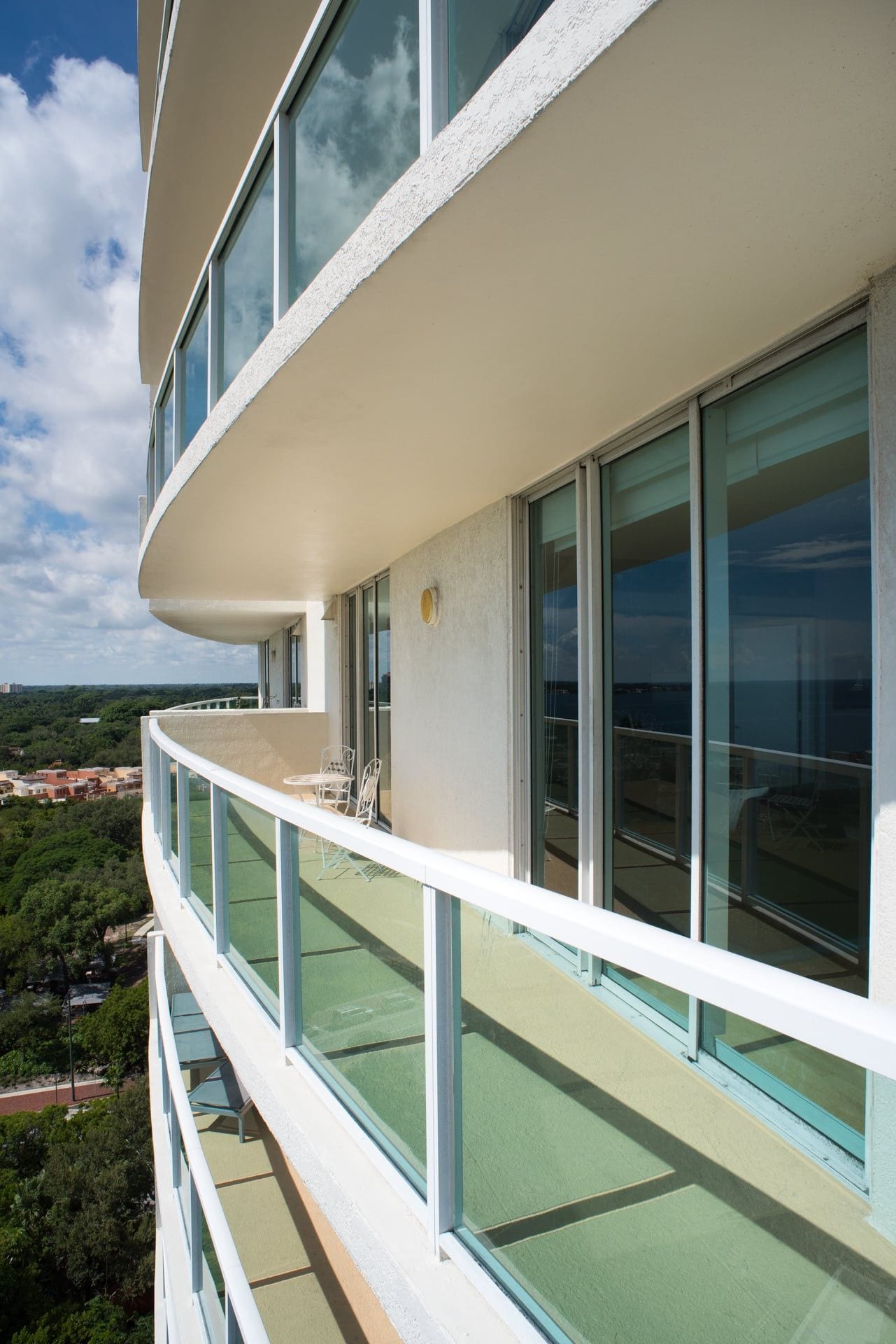 Un immeuble à plusieurs étages doté de balcons, de grandes fenêtres et offrant une vue sur le paysage environnant.