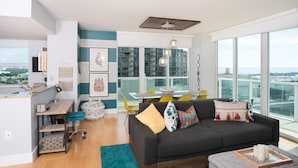 Un espacio moderno para vivir con cocina, comedor y un amplio ventanal con vista a la ciudad.