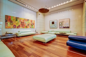 A modern lobby with a wooden floor, white sofas, and abstract paintings on the walls. - Cozy Grove Stay Free Parking, Pool Access, Walk to Cafés & Parks (Miami)