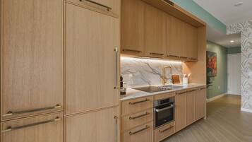 Una cocina moderna con armarios de madera, encimera de mármol y electrodomésticos de acero inoxidable.