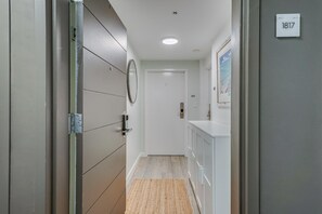 Corredor com porta identificada como '1817', espelho e tapete pequeno.